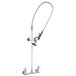 A silver T&S EasyInstall wall mounted pre-rinse faucet with a hose.