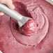 A hand using a metal scoop to serve Hometown Provisions Organic Acai Sorbet