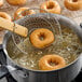 South Chicago Packing All Donut Beef Tallow Shortening being used to fry donuts in a pan.