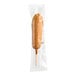 A Foster Farms Reduced-Sodium Whole Grain Corn Dog in a plastic wrapper.