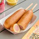 A pink box of Foster Farms Honey Chicken Corn Dogs on a table.