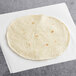 An El Mejor flour tortilla on a white surface.