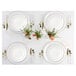 A white table setting with a Posh Setting gold and white plastic fork on a white plate with gold trim and a bouquet of flowers.