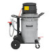 A grey Nilfisk wet dry vac on a cart with a hose attached.