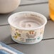 A close up of a Painterland Sisters Blueberry Lemon Organic Skyr Yogurt cup on a table.
