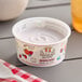 A Painterland Sisters Meadow Berry yogurt cup on a table.