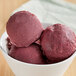 A bowl of acai ice cream with red berries on top.