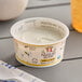 A container of Painterland Sisters Vanilla Bean Skyr Yogurt with a spoon on a table.