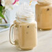 A glass mug of coffee with SHOTT Almond flavoring syrup and whipped cream on top.