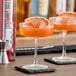 A glass of SHOTT Pink Grapefruit flavored drink garnished with a grapefruit slice.