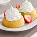 Two small desserts topped with So Delicious Cocowhip and strawberries.