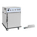 A stainless steel undercounter cook and hold smoker oven with control knobs, a front door, casters, and a separate smoker box with a power cord.