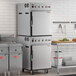 A stacked stainless steel cook and hold oven with smoker feature in a commercial kitchen setting.