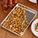 A Choice aluminum bun pan with tater tots on a table.