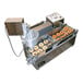 A Belshaw Donut Robot Mark II liquid propane automatic doughnut fryer with mini plunger and a tray of doughnuts.