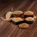 Bowls of different types of grain on a table with a scoop.