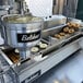A Belshaw Donut Robot Mark II making plain doughnuts.