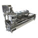 A Belshaw Donut Robot Mark V automatic donut fryer with a bowl on it.