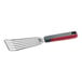 A stainless steel slotted fish and egg turner with a red and gray nylon handle.