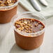 A Nats Rawline plant-based chocolate mousse cup with chocolate and nuts.