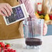 A person pouring Especial Fruits Acai Puree Smoothie Mix into a blender.