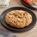 An Otis Spunkmeyer apple cinnamon oatmeal cookie on a plate.
