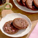A plate of Otis Spunkmeyer chocolate cookies with pink chocolate candy gems.