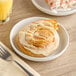 An Otis Spunkmeyer Iced Cinnamon Roll on a plate with a fork.