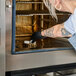 A person placing cleaning tablets inside a Vulcan Chef'sCombi CHEF-101E-208 10 pan half size electric combi oven.
