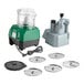 A combination food processor set with a green and black base, clear plastic bowl, continuous feed attachment, and six metal discs.