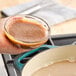A person pouring Better Than Bouillon Baked Ham flavor into a pot.