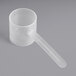 A clear plastic measuring scoop with a long handle.