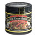 A black jar of Better Than Bouillon Premium Roasted Beef Flavor Base with a yellow label on a table in a professional kitchen.
