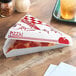 A red and white Southern Champion pizza box holding a slice of pizza.