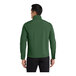 A man wearing a Port Authority forest green soft shell jacket with a zipper and pockets.