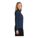 A woman wearing a navy blue Port Authority core soft shell jacket.