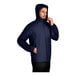 A man wearing a Port Authority navy rain jacket with a full zip.