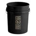 A black BWAY 5 gallon round pail with a metal handle and a warning label.