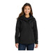 A woman wearing a black Port Authority all-conditions parka jacket.