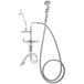 A T&S deck mounted pre-rinse faucet with a silver hose and double jointed faucet attachment.