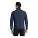 A man wearing a Port Authority navy blue core soft shell jacket with a full zip.