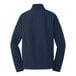 A back view of a Port Authority navy blue core soft shell jacket with long sleeves.
