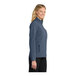A close-up of a navy heather women's Port Authority soft shell jacket with zippered pockets.
