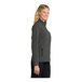 A woman wearing a black and charcoal Port Authority Core Soft Shell Jacket.