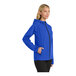 A woman wearing a blue Port Authority rain jacket with a zipper.