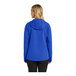 A woman wearing a Port Authority blue rain jacket with a hood.