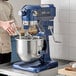 A man standing in front of a blue Waring Luna planetary stand mixer.