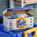 A box of Tide Professional powder laundry detergent with a scoop inside.