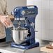 A man using a Waring Luna blue stand mixer with a silver bowl.