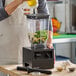 A Blendtec Chef blender with a toggle control and a 96 oz. jar being used to blend ingredients in a kitchen setting.